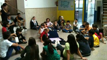 Els infants del Centre Obert observant el llibre gegant